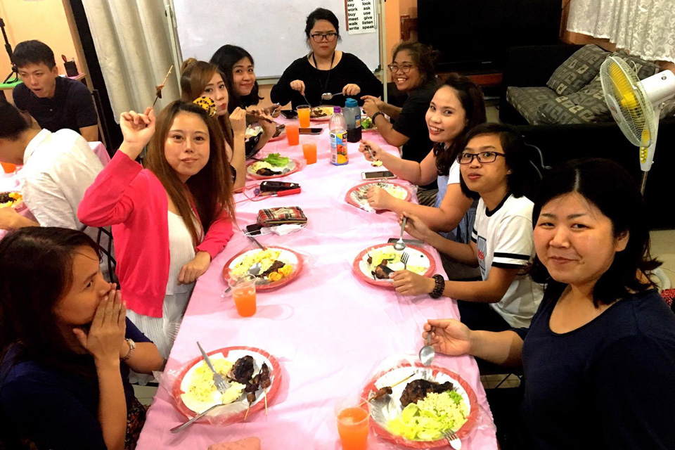 先生と一緒に食事を食べるマニラのアットホームな日本人経営学校b.E.Camp